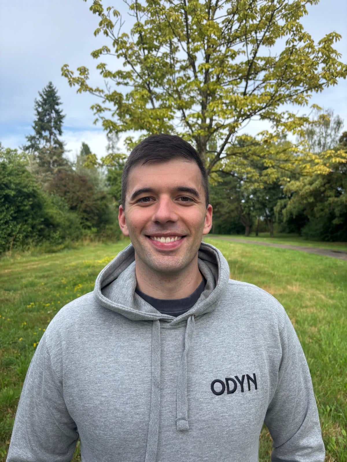 ODYN Founder wearing a gray hoodie with 'ODYN' logo outdoors